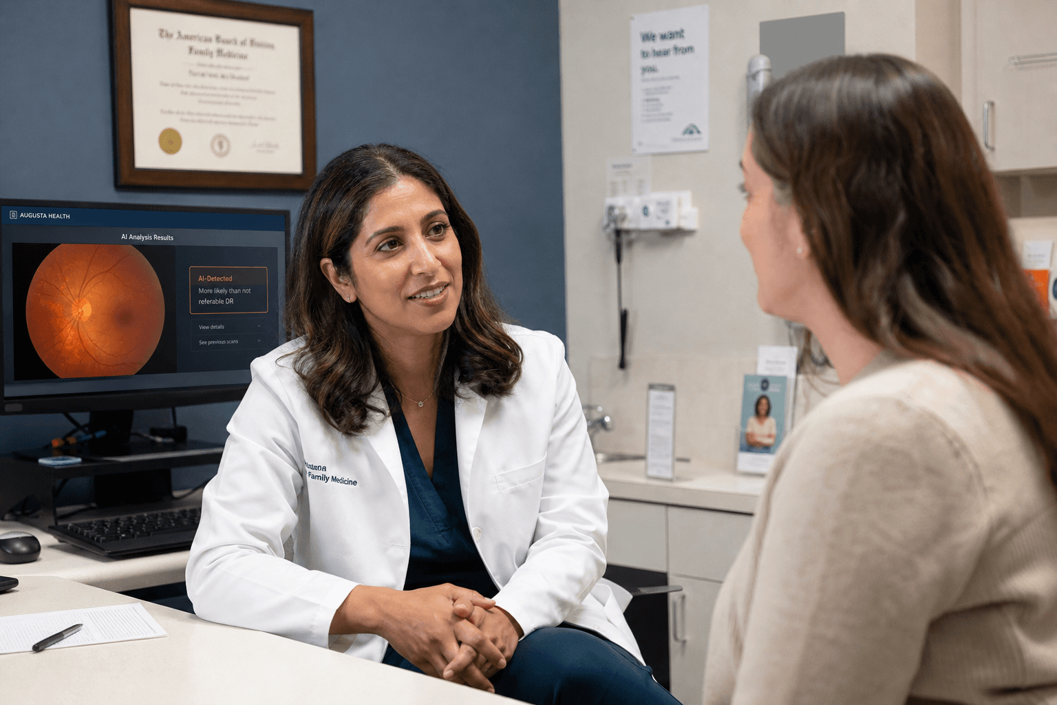 A primary care physician in conversation with a patient, with a secondary monitor showing a retinal scan AI result in the background